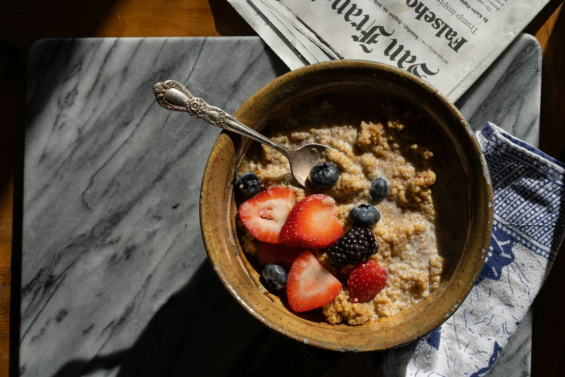 Warm grain bowl topped with strawberries and blueberries